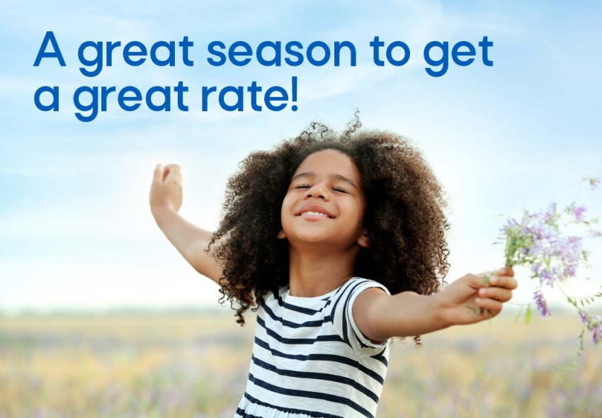 Girl smiling holding flowers in a field