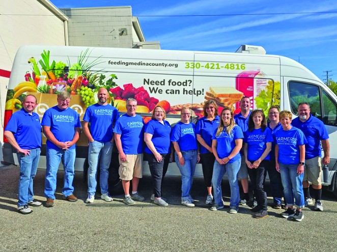 Group of volunteers standing outside of Feeding Medina Food Bank.